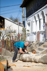 Strong lumberjack carrying a big beech log to split