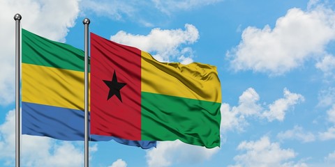 Gabon and Guinea Bissau flag waving in the wind against white cloudy blue sky together. Diplomacy concept, international relations.