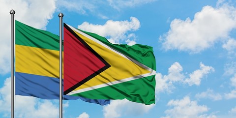 Gabon and Guyana flag waving in the wind against white cloudy blue sky together. Diplomacy concept, international relations.