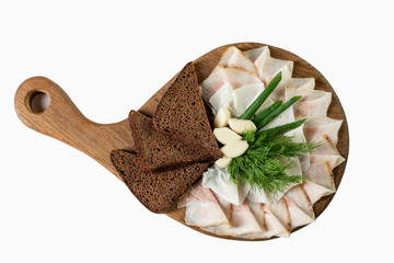Fat with garlic and black croutons on a wooden board. Traditional appetizing snack. Top view. Isolated over white background.