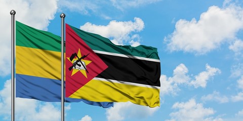 Gabon and Mozambique flag waving in the wind against white cloudy blue sky together. Diplomacy concept, international relations.