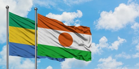 Gabon and Niger flag waving in the wind against white cloudy blue sky together. Diplomacy concept,...