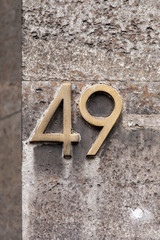 brass number 49 on granite stone wall
