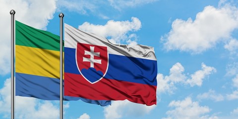 Gabon and Slovakia flag waving in the wind against white cloudy blue sky together. Diplomacy concept, international relations.