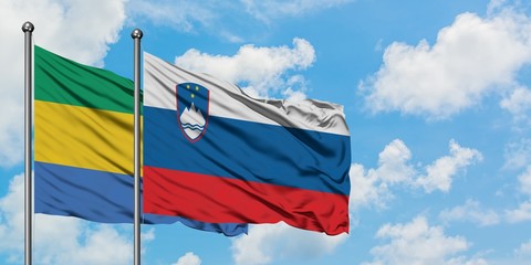 Gabon and Slovenia flag waving in the wind against white cloudy blue sky together. Diplomacy concept, international relations.