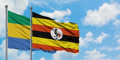 Gabon and Uganda flag waving in the wind against white cloudy blue sky together. Diplomacy concept,...