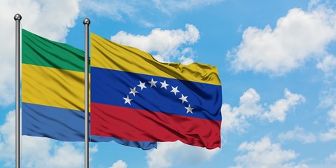 Gabon and Venezuela flag waving in the wind against white cloudy blue sky together. Diplomacy concept, international relations.
