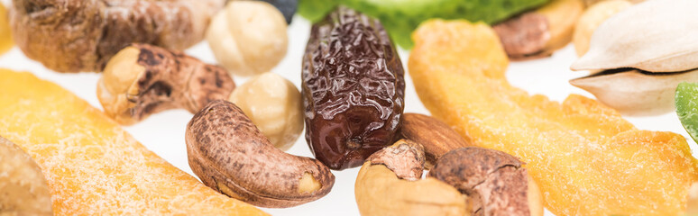 close up view of Turkish assorted nuts, dried fruits and candied fruit isolated on white, panoramic shot