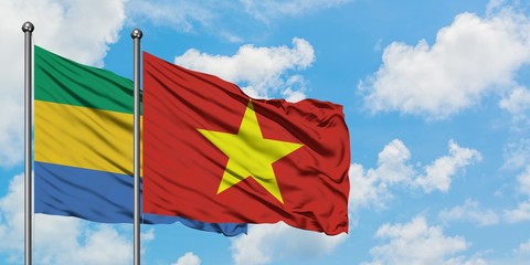 Gabon and Vietnam flag waving in the wind against white cloudy blue sky together. Diplomacy concept, international relations.