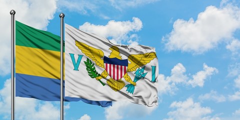 Gabon and United States Virgin Islands flag waving in the wind against white cloudy blue sky...