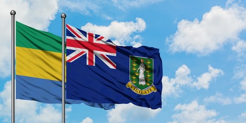 Gabon and British Virgin Islands flag waving in the wind against white cloudy blue sky together. Diplomacy concept, international relations.