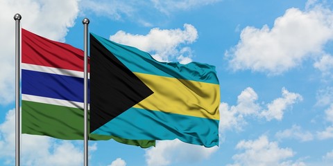 Gambia and Bahamas flag waving in the wind against white cloudy blue sky together. Diplomacy concept, international relations.