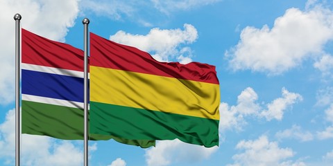 Gambia and Bolivia flag waving in the wind against white cloudy blue sky together. Diplomacy concept, international relations.