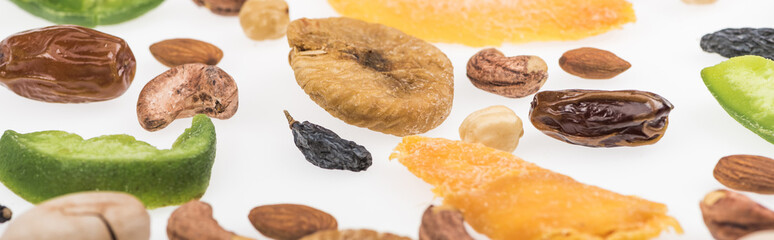 close up view of assorted nuts, dried fruits and candied fruit isolated on white, panoramic shot