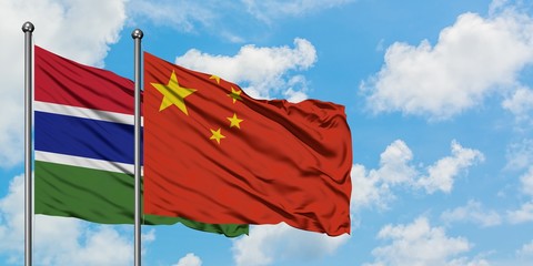 Gambia and China flag waving in the wind against white cloudy blue sky together. Diplomacy concept, international relations.