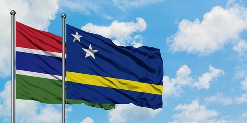 Gambia and Curacao flag waving in the wind against white cloudy blue sky together. Diplomacy concept, international relations.