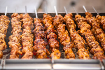 Chicken kebabs cooking on a charcoal grill at Christmas market winter wonderland in London