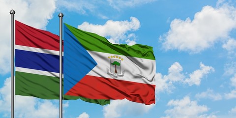 Gambia and Equatorial Guinea flag waving in the wind against white cloudy blue sky together. Diplomacy concept, international relations.