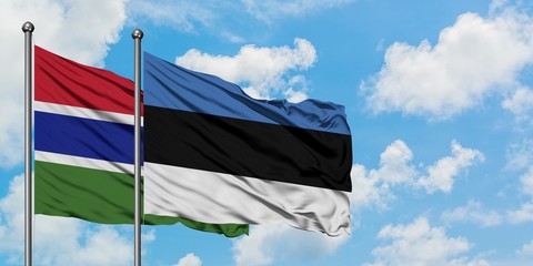 Gambia and Estonia flag waving in the wind against white cloudy blue sky together. Diplomacy concept, international relations.