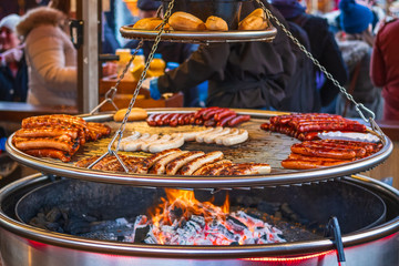 Grilling sausages on barbecue grill at Christmas market winter wonderland in London