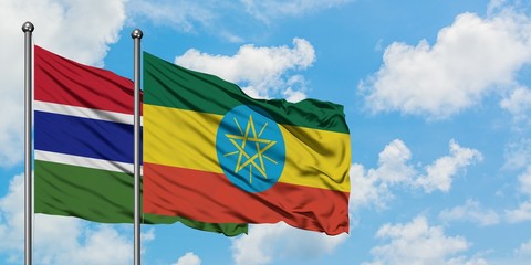 Gambia and Ethiopia flag waving in the wind against white cloudy blue sky together. Diplomacy concept, international relations.