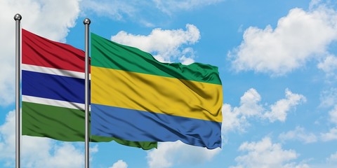 Gambia and Gabon flag waving in the wind against white cloudy blue sky together. Diplomacy concept, international relations.