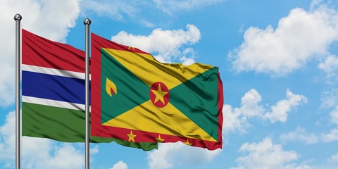 Gambia and Grenada flag waving in the wind against white cloudy blue sky together. Diplomacy concept, international relations.