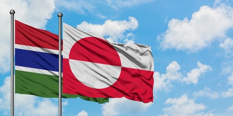 Gambia and Greenland flag waving in the wind against white cloudy blue sky together. Diplomacy concept, international relations.