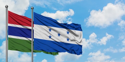 Gambia and Honduras flag waving in the wind against white cloudy blue sky together. Diplomacy concept, international relations.