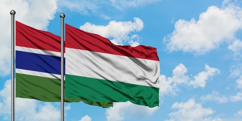 Gambia and Hungary flag waving in the wind against white cloudy blue sky together. Diplomacy concept, international relations.