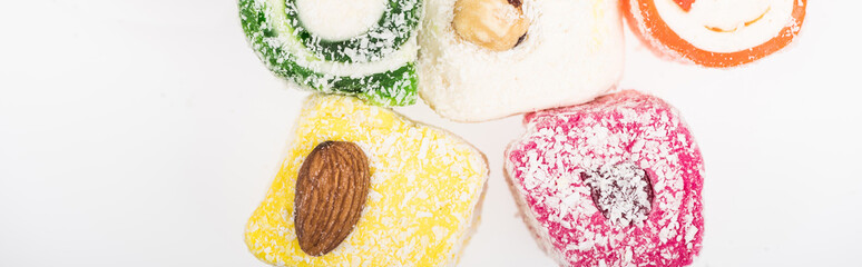 top view of assorted delicious turkish delight in coconut flakes isolated on white, panoramic shot