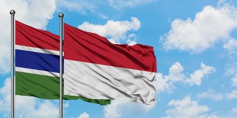 Gambia and Indonesia flag waving in the wind against white cloudy blue sky together. Diplomacy concept, international relations.