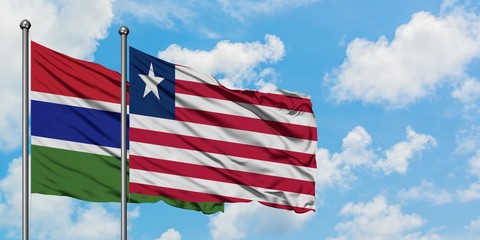 Gambia and Liberia flag waving in the wind against white cloudy blue sky together. Diplomacy concept, international relations.