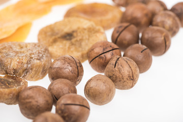 close up view of dried mango slices, figs and macadamia nuts isolated on white