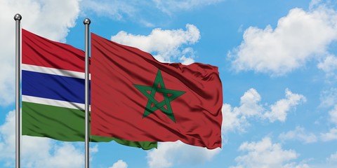 Gambia and Morocco flag waving in the wind against white cloudy blue sky together. Diplomacy concept, international relations.