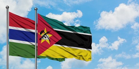 Gambia and Mozambique flag waving in the wind against white cloudy blue sky together. Diplomacy concept, international relations.