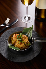 delicious grilled scallops served with cutlery and white wine on wooden table