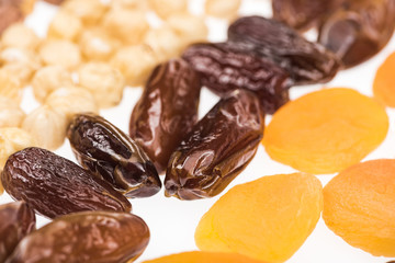 close up view of dried apricots, dates and hazelnut isolated on white