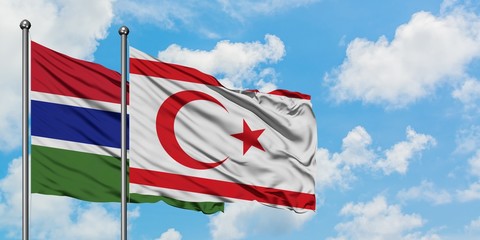 Gambia and Northern Cyprus flag waving in the wind against white cloudy blue sky together. Diplomacy concept, international relations.
