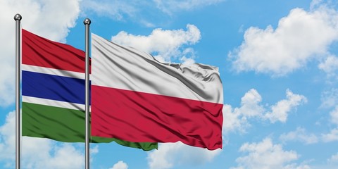 Gambia and Poland flag waving in the wind against white cloudy blue sky together. Diplomacy concept, international relations.