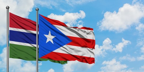 Gambia and Puerto Rico flag waving in the wind against white cloudy blue sky together. Diplomacy concept, international relations.