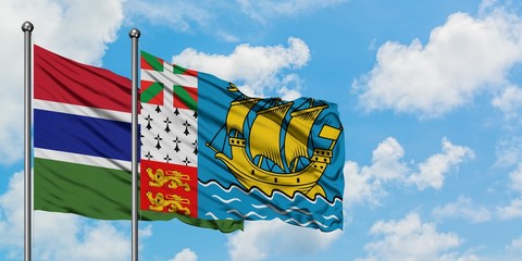 Gambia and Saint Pierre And Miquelon flag waving in the wind against white cloudy blue sky together. Diplomacy concept, international relations.