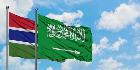 Gambia and Saudi Arabia flag waving in the wind against white cloudy blue sky together. Diplomacy concept, international relations.