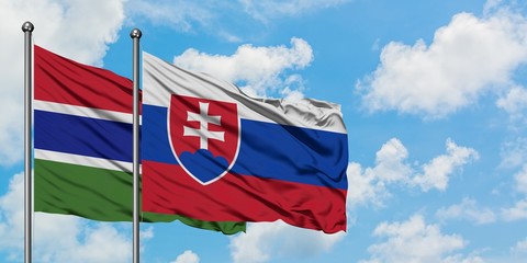 Gambia and Slovakia flag waving in the wind against white cloudy blue sky together. Diplomacy concept, international relations.