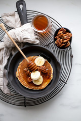 Pancakes with banana, walnuts and honey. Morning concept
