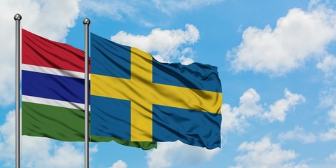Gambia and Sweden flag waving in the wind against white cloudy blue sky together. Diplomacy concept, international relations.