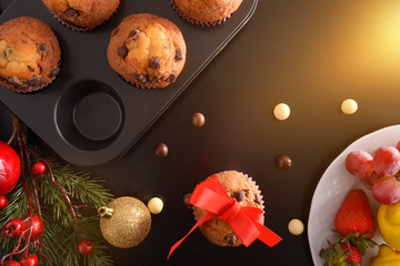 Homemade baked chocolate muffins on black christmas table top flash