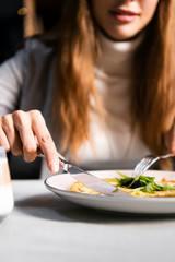 cropped view of woman eating omelet for breakfast in cafe