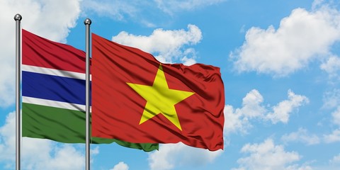 Gambia and Vietnam flag waving in the wind against white cloudy blue sky together. Diplomacy concept, international relations.