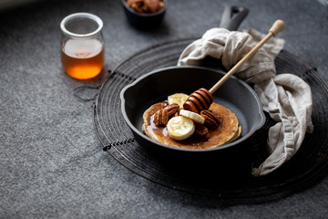 Pancakes with banana, walnuts and honey. Morning concept